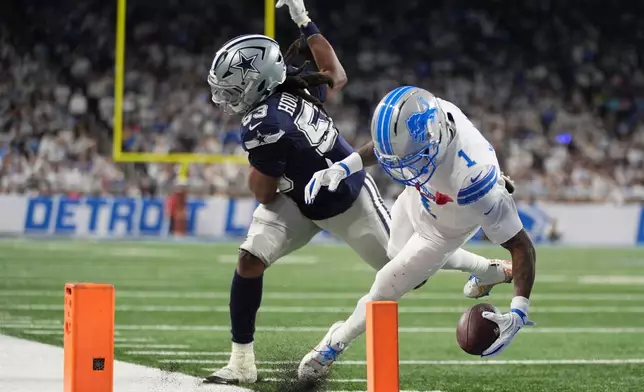 Detroit Lions wide receiver Jameson Williams (1) is stopped short of the goal line by Dallas Cowboys defensive end James Houston (53) during the first half of an NFL football game Thursday, Dec. 4, 2025, in Detroit. (AP Photo/Ryan Sun)