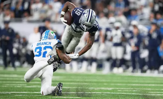 Dallas Cowboys wide receiver Ryan Flournoy (19) takes a hit from Detroit Lions safety Brian Branch (32) during the second half of an NFL football game Thursday, Dec. 4, 2025, in Detroit. (AP Photo/Ryan Sun)