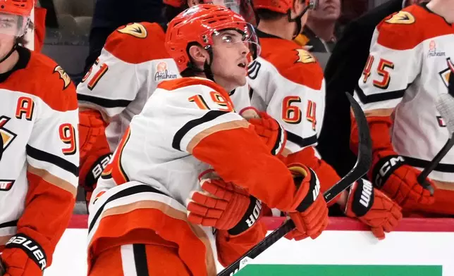 Anaheim Ducks' Troy Terry (19) looks at the replay of his goal as he returns to the bench after scoring during the second period of an NHL hockey game against the Pittsburgh Penguins in Pittsburgh, Tuesday, Dec. 9, 2025. (AP Photo/Gene J. Puskar)