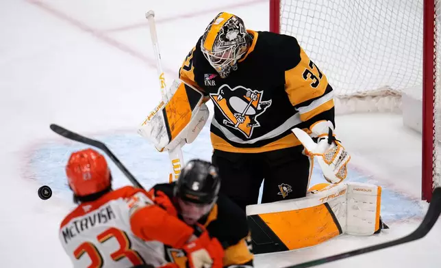 Pittsburgh Penguins goaltender Arturs Silovs (37) blocks a shot by Anaheim Ducks' Mason McTavish (23) during the first period of an NHL hockey game, in Pittsburgh, Tuesday, Dec. 9, 2025. (AP Photo/Gene J. Puskar)