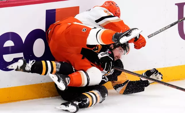 Anaheim Ducks' Olen Zellweger, top, collides with Pittsburgh Penguins' Connor Dewar during the first period of an NHL hockey game in Pittsburgh, Tuesday, Dec. 9, 2025. (AP Photo/Gene J. Puskar)