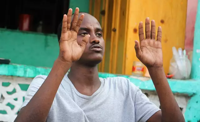 Mohamed Abdi Awale, who says he was captured and tortured by smugglers while attempting to reach Europe, gestures during an interview with The Associated Press in Mogadishu, Somalia, Monday, Nov. 17, 2025. (AP Photo/Farah Abdi Warsameh)
