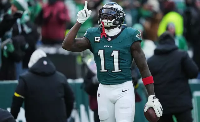 Philadelphia Eagles wide receiver A.J. Brown (11) celebrates scoring a touchdown during the second half of an NFL football game against the Las Vegas Raiders on Sunday, Dec. 14, 2025, in Philadelphia. (AP Photo/Matt Rourke)