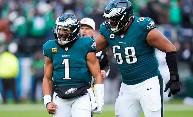 Philadelphia Eagles quarterback Jalen Hurts (1) and Eagles offensive tackle Jordan Mailata (68) celebrate the touchdown of Eagles wide receiver A.J. Brown during the second half of an NFL football game against the Las Vegas Raiders on Sunday, Dec. 14, 2025, in Philadelphia. (AP Photo/Chris Szagola)