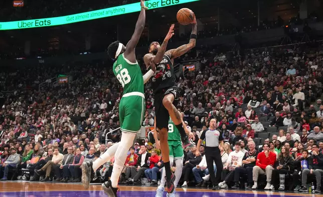 Toronto Raptors forward Brandon Ingram (3) goes up to shoot over Boston Celtics' Neemias Queta (88) during first-half NBA basketball game action in Toronto, Sunday Dec. 7, 2025. (Chris Young/The Canadian Press via AP)