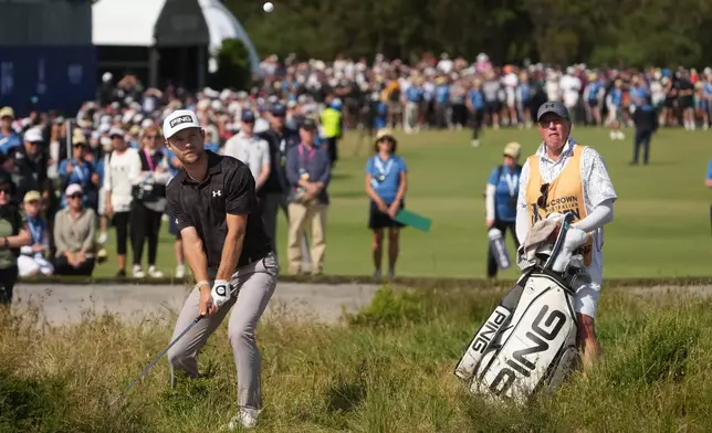 Denmark's Rasmus Neergaard-Petersen, left, plays from the rough on the 18th green as his caddy Brian Nilsson watches during the final round of the Australian Open golf tournament in Melbourne, Australia, Sunday, Dec. 7, 2025. (AP Photo/Asanka Brendon Ratnayake)