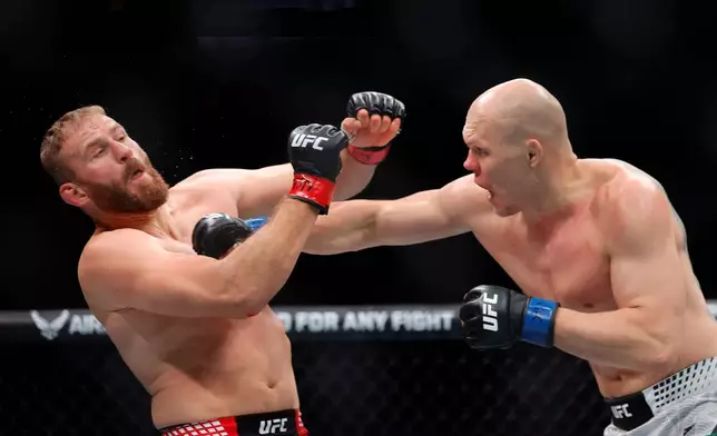 Jan Blachowicz, left, takes a punch from Bogdan Guskov, right, in a light heavyweight mixed martial arts bout during UFC 323, Saturday, Dec. 6, 2025, in Las Vegas. (Steve Marcus/Las Vegas Sun via AP)