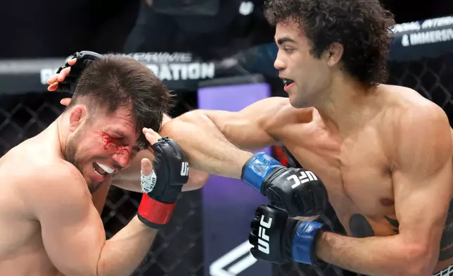 Henry Cejudo, left, is hit with an elbow by Payton Talbott, right, in a bantamweight mixed martial arts bout during UFC 323, Saturday, Dec. 6, 2025, in Las Vegas. (Steve Marcus/Las Vegas Sun via AP)