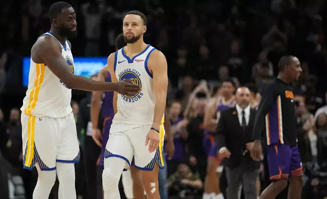 Golden State Warriors guard Stephen Curry (30) and Warriors forward Draymond Green react as time expires during the second half of an NBA basketball game loss to the Phoenix Suns Thursday, Dec. 18, 2025, in Phoenix. (AP Photo/Ross D. Franklin)