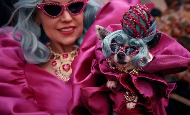 A reveler holds her dog as she participates in the annual Easter Parade and Bonnet Festival in front of St. Patrick's Cathedral, in New York, April 20, 2025. (AP Photo/Andres Kudacki, File)