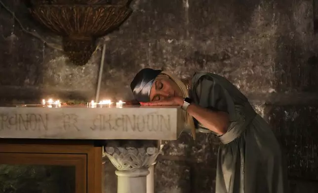 A Christian pilgrim rests her head while praying during Easter Sunday Mass at the Church of the Holy Sepulcher, in Jerusalem's Old City, April 20, 2025. (AP Photo/Mahmoud Illean, File)