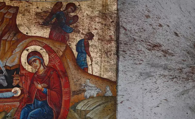 Blood stains a religious icon of the Virgin Mary and child inside the Mar Elias Greek Orthodox Church, during a memorial service, a day after a suicide bombing, in Dweil'a on the outskirts of Damascus, Syria, June 23, 2025. (AP Photo/Omar Sanadiki, File)