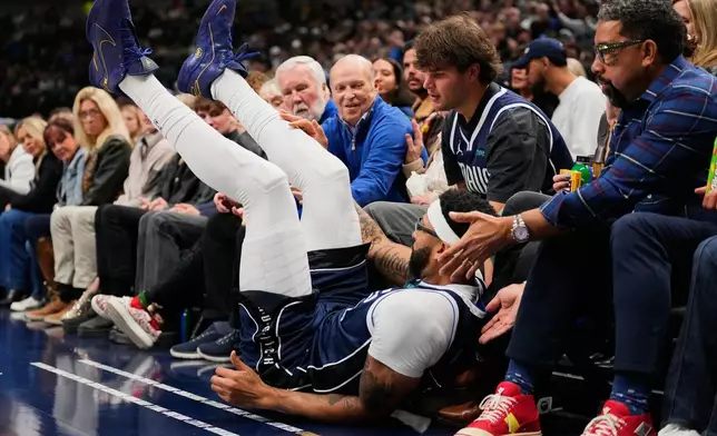 Dallas Mavericks forward Anthony Davis takes a spill in the first half of an NBA basketball game against the Brooklyn Nets in Dallas, Friday, Dec. 12, 2025. (AP Photo/Tony Gutierrez)