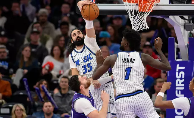 Orlando Magic center Goga Bitadze (35) blocks the shot of Utah Jazz center Jusuf Nurkic, bottom left, during the first half of an NBA basketball game, Saturday, Dec. 20, 2025, in Salt Lake City. (AP Photo/Tyler Tate)