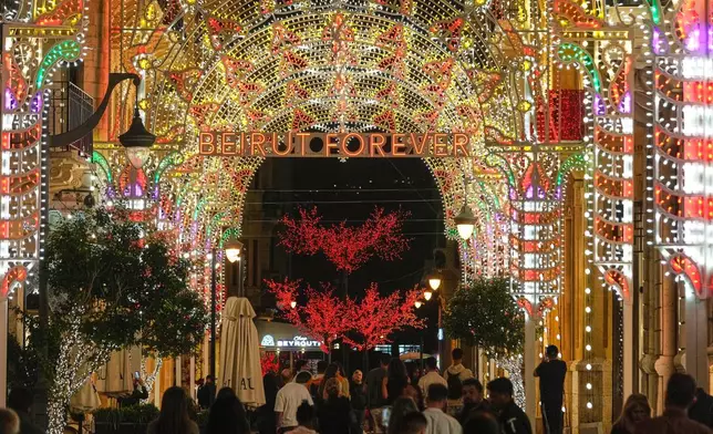 FILE - People walk past Christmas decorations in downtown Beirut, Lebanon, Wednesday, Nov. 26, 2025. (AP Photo/Hussein Malla, File)
