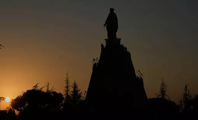 Worshippers visit Our Lady of Lebanon shrine in Harissa, north of Beirut, Lebanon, Sunday, Nov. 9, 2025, as the sun sets over the Mediterranean Sea. (AP Photo/Hassan Ammar)
