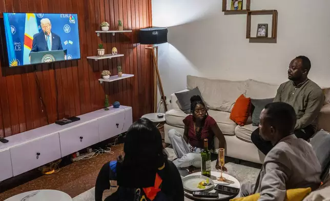A family watches the live broadcast of the signing ceremony for the peace agreement between Rwanda and the DRC in Goma, Democratic Republic of the Congo, Dec. 4, 2025. (AP Photo/Moses Sawasawa)