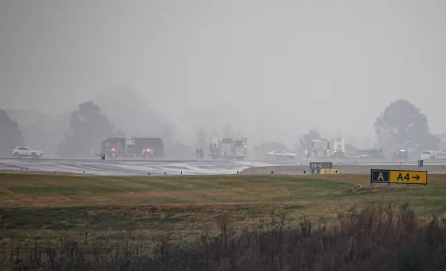 First responders tend to the scene of a reported plane crash at a regional airport in Statesville, N.C., Thursday, Dec. 18, 2025. (AP Photo/Matt Kelley)
