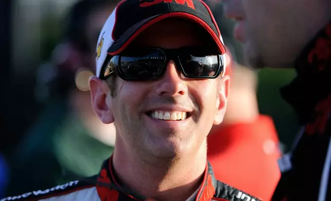 FILE - Greg Biffle smiles along pit row during qualifying for Sunday's NASCAR Sprint Cup Series auto race at Atlanta Motor Speedway, Friday, Aug. 31, 2012, in Hampton, Ga. (AP Photo/David Tulis, File)