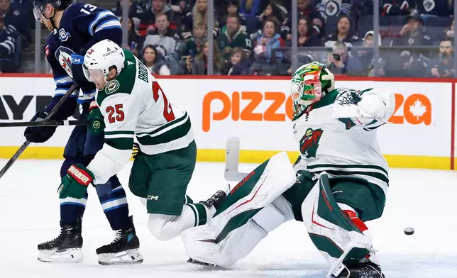 Minnesota Wild's Jonas Brodin (25) and goaltender Jesper Wallstedt (30) collide during the second period of an NHL hockey game in Winnipeg, Manitoba, Saturday, Dec. 27, 2025. (John Woods/The Canadian Press via AP)