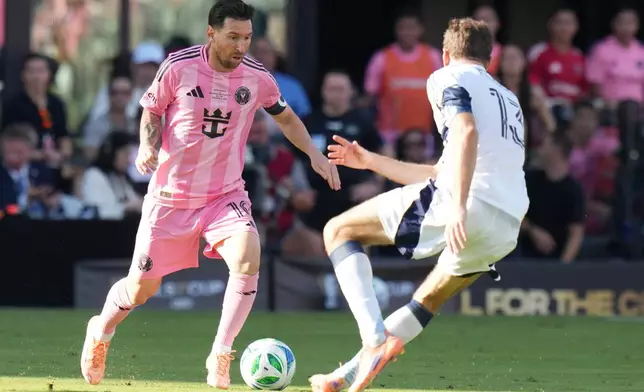 Inter Miami forward Lionel Messi (10) runs with the ball as Vancouver Whitecaps forward Thomas Müller (13) defends during the first half of the MLS Cup final soccer match Saturday, Dec. 6, 2025, in Fort Lauderdale, Fla. (AP Photo/Lynne Sladky)