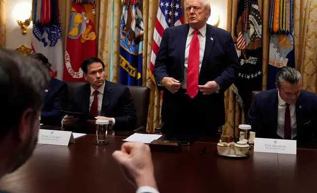 Vice President JD Vance pumps his fist as President Donald Trump stands up following a Cabinet meeting at the White House, Tuesday, Dec. 2, 2025, in Washington. With the President are Secretary of State Marco Rubio, seated left, and Defense Secretary Pete Hegseth, seated right. (AP Photo/Julia Demaree Nikhinson)