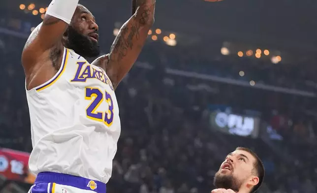 Los Angeles Lakers forward Lebron James (23) dunks as Los Angeles Clippers center Ivica Zubac (40) looks on during the first half of an NBA basketball game Saturday, Dec. 20, 2025, in Inglewood, Calif. (AP Photo/Jae C. Hong)