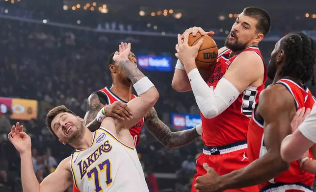 Los Angeles Clippers center Ivica Zubac, left, gets a rebound against Los Angeles Lakers forward/guard Luka Doncic during the first half of an NBA basketball game Saturday, Dec. 20, 2025, in Inglewood, Calif. (AP Photo/Jae C. Hong)