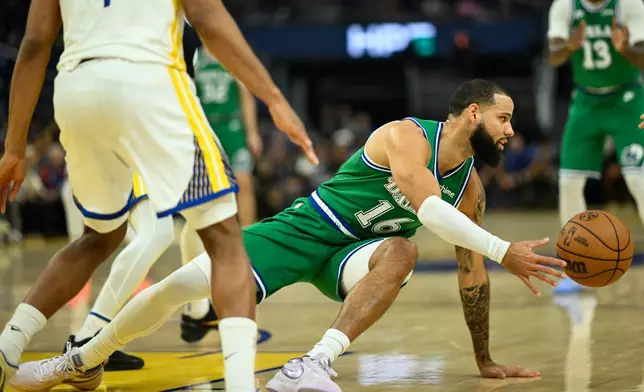 Dallas Mavericks forward Caleb Martin, right, attempts a pass against the Golden State Warriors during the first half of an NBA basketball game, Thursday, Dec. 25, 2025, in San Francisco. (AP Photo/Eakin Howard)
