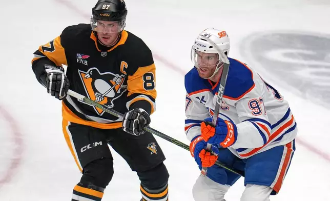 Pittsburgh Penguins' Sidney Crosby (87) defends against Edmonton Oilers' Connor McDavid during the first period of an NHL hockey game in Pittsburgh, Tuesday, Dec. 16, 2025. (AP Photo/Gene J. Puskar)
