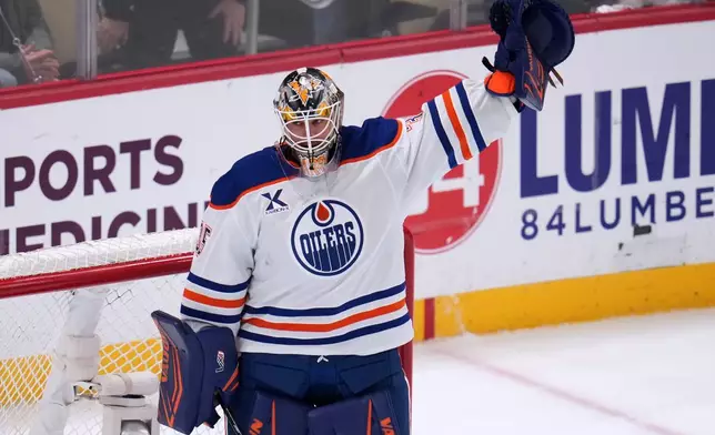 Edmonton Oilers goaltender Tristan Jarry acknowledges fans after a tribute to his time with the Pittsburgh Penguins during a first period timeout during an NHL hockey game against the Pittsburgh Penguins, in Pittsburgh, Tuesday, Dec. 16, 2025. (AP Photo/Gene J. Puskar)