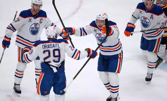 Edmonton Oilers' Leon Draisaitl (29) celebrates with Zach Hyman (18) and Connor McDavid (97) after scoring during the first period of an NHL hockey game against the Pittsburgh Penguins in Pittsburgh, Tuesday, Dec. 16, 2025. (AP Photo/Gene J. Puskar)