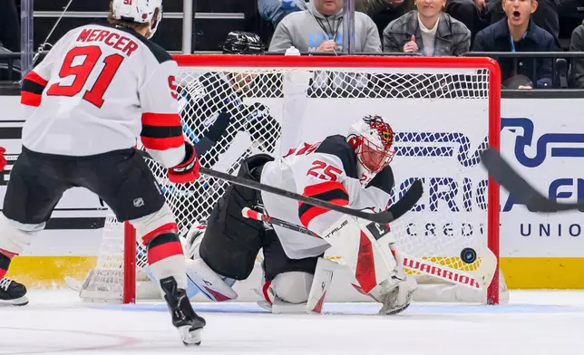 New Jersey Devils goaltender Jacob Markstrom (25) makes a stick save during the second period of an NHL hockey game against the Utah Mammoth, Friday, Dec. 19, 2025, in Salt Lake City. (AP Photo/Tyler Tate)