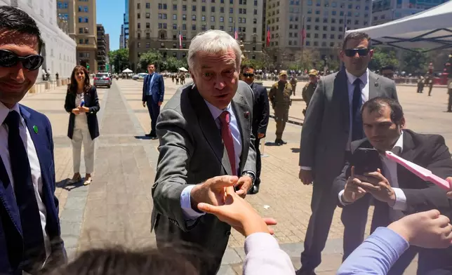 Chilean President-elect Jose Antonio Kast greets supporters at La Moneda palace after meeting with President Gabriel Boric the day after he won the presidential election runoff in Santiago, Chile, Monday, Dec. 15, 2025. (AP Photo/Esteban Felix)
