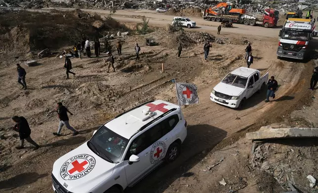 Hamas militants and Egyptian workers accompanied by members of the International Committee of the Red Cross (ICRC) head to Zeitoun neighborhood of Gaza City to search for the remains of deceased hostages, Monday, Dec. 8, 2025. (AP Photo/Jehad Alshrafi)