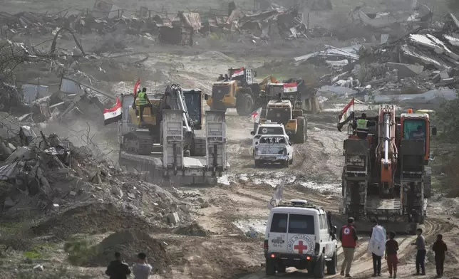 Hamas militants and Egyptian workers accompanied by members of the International Committee of the Red Cross (ICRC) head to Zeitoun neighborhood of Gaza City to search for the remains of deceased hostages, Monday, Dec. 8, 2025. (AP Photo/Jehad Alshrafi)