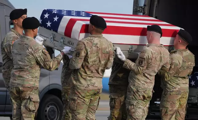 An Army carry team places the flag-draped transfer case with the remains of civilian interpreter Ayad Mansoor Sakat of Macomb, Mich., into the transfer vehicle during a casualty return, Wednesday, Dec. 17, 2025, at Dover Air Force Base, Del. (AP Photo/Evan Vucci)