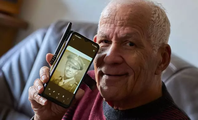 ***HOLD FOR STORY BY MOLLY QUELL SLUGGED NETHERLANDS BLACK LIBERATORS*** Seventy-nine-year-old Cor Linssen, son of a Black WWII soldier and a White mother, shows a picture of his father on his mobile phone during an interview in Roermond, Netherlands, Thursday, Dec. 11, 2025. (AP Photo/Peter Dejong)