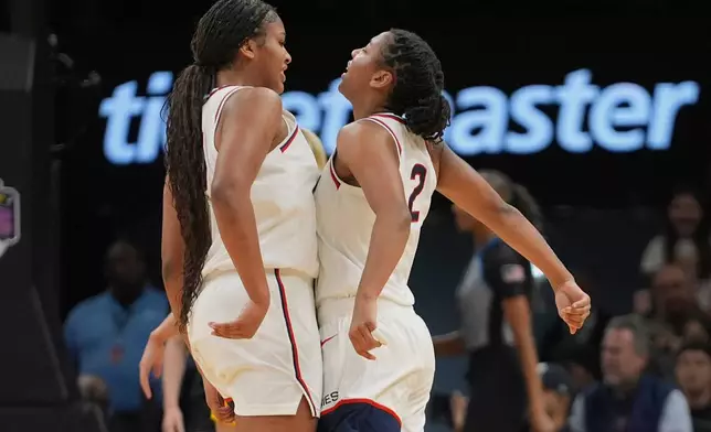 UConn's KK Arnold, right, celebrates with Sarah Strong (21) during the first half of an NCAA college basketball game against the Iowa Saturday, Dec. 20, 2025, in New York. (AP Photo/Frank Franklin II)
