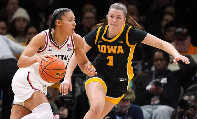 UConn's Azzi Fudd, left, drives past Iowa's Taylor Stremlow during the first half of an NCAA college basketball game Saturday, Dec. 20, 2025, in New York. (AP Photo/Frank Franklin II)
