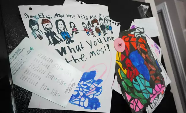 A child's drawing showing Edwin Sanchez-Mendoza and Cristina Osornio's family is seen on their refrigerator, Nov. 18, 2025, in Rogers, Ark. (AP Photo/Julio Cortez)