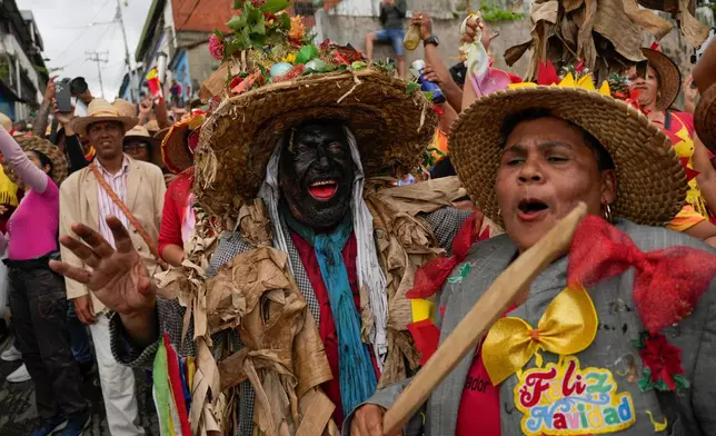 Revelers take part in the centuries-old Afro-Venezuelan Holy Innocents celebration in Caucagua, Venezuela, Sunday, Dec. 28, 2025. (AP Photo/Matias Delacroix)