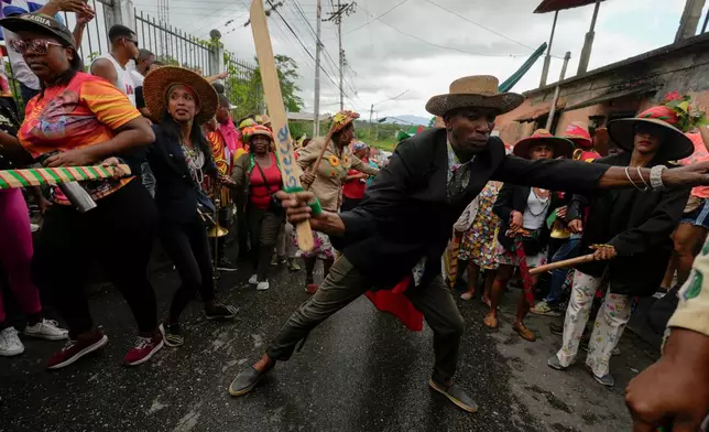 Revelers take part in the centuries-old Afro-Venezuelan Holy Innocents celebration in Caucagua, Venezuela, Sunday, Dec. 28, 2025. (AP Photo/Matias Delacroix)