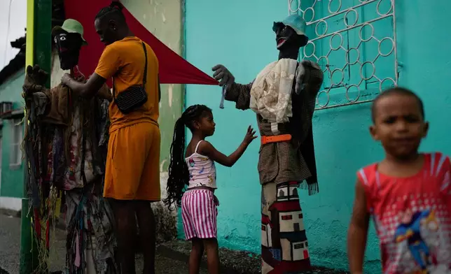 Revelers take part in the centuries-old Afro-Venezuelan Holy Innocents celebration in Caucagua, Venezuela, Sunday, Dec. 28, 2025. (AP Photo/Matias Delacroix)