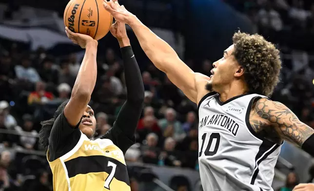 Washington Wizards guard Bub Carrington (7) shoots as San Antonio Spurs forward Jeremy Sochan (10) defends during the first half of an NBA basketball game in San Antonio, Thursday, Dec. 18, 2025. (AP Photo/Billy Calzada)