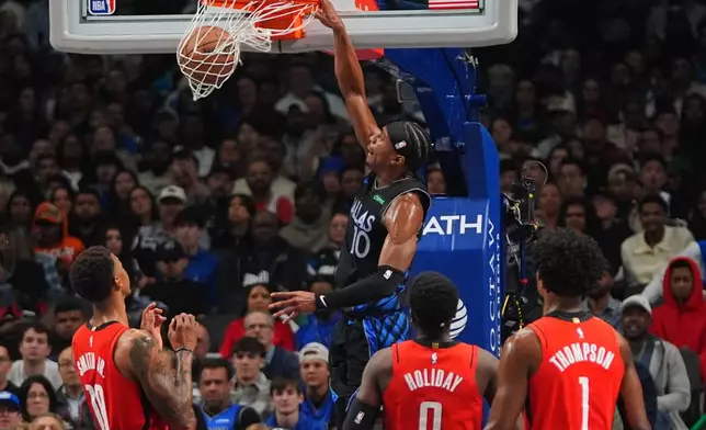 Dallas Mavericks guard Brandon Williams (10) dunks in front of Houston Rockets defenders Jabari Smith Jr. (10), Aaron Holiday (0) and Amen Thompson (1) during the first half of an NBA basketball game in Dallas, Saturday, Dec. 6, 2025. (AP Photo/LM Otero)