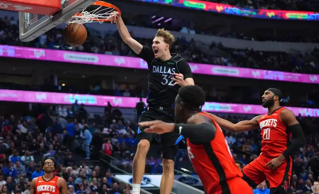 Dallas Mavericks forward Cooper Flagg (32) slam-dunks against Houston Rockets defenders Josh Okogie (20), Aaron Holiday, front right, and Isaiah Crawford (27) during the second half of an NBA basketball game in Dallas, Saturday, Dec. 6, 2025. (AP Photo/LM Otero)