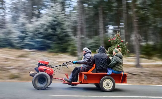 People drive up to the top of the Feldberg mountain near Frankfurt, Germany, to join the traditional Christmas Eve meeting of tractor and motorbike drivers early Wednesday, Dec. 24, 2025. (AP Photo/Michael Probst)