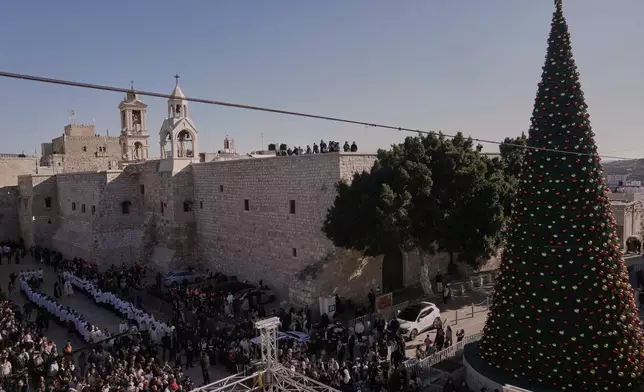 Catholic clergy walk in procession next to the Church of the Nativity, traditionally believed to be the birthplace of Jesus, on Christmas Eve, in the West Bank city of Bethlehem, Wednesday, Dec. 24, 2025. (AP Photo/Mahmoud Illean)