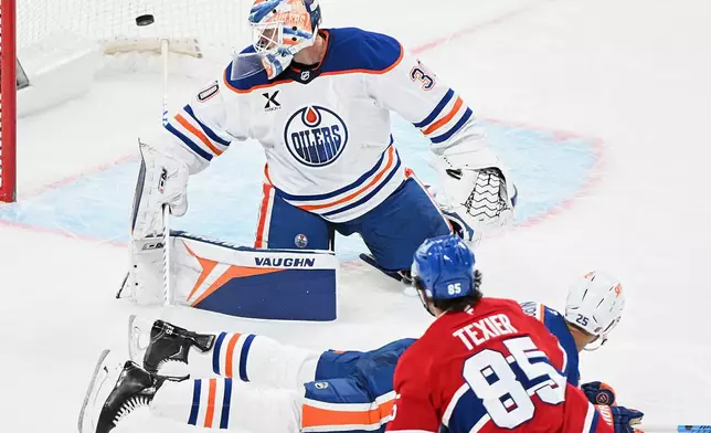 Montreal Canadiens' Alexandre Texier (85) scores against Edmonton Oilers goaltender Calvin Pickard (30) as Oilers' Darnell Nurse (25) tries to block the shot during the third period of an NHL hockey game, in Montreal, Sunday, Dec. 14, 2025. (Graham Hughes/The Canadian Press via AP)